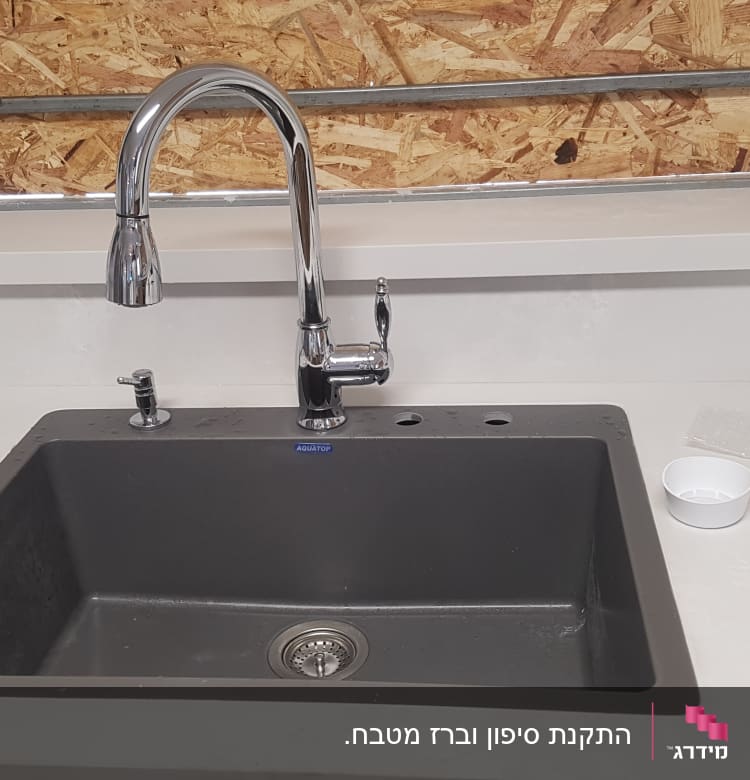כיור מטבח עם ברז כרום ומסמכים על השיש